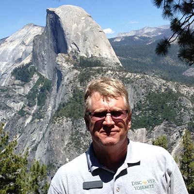 man in front of half dome mountain